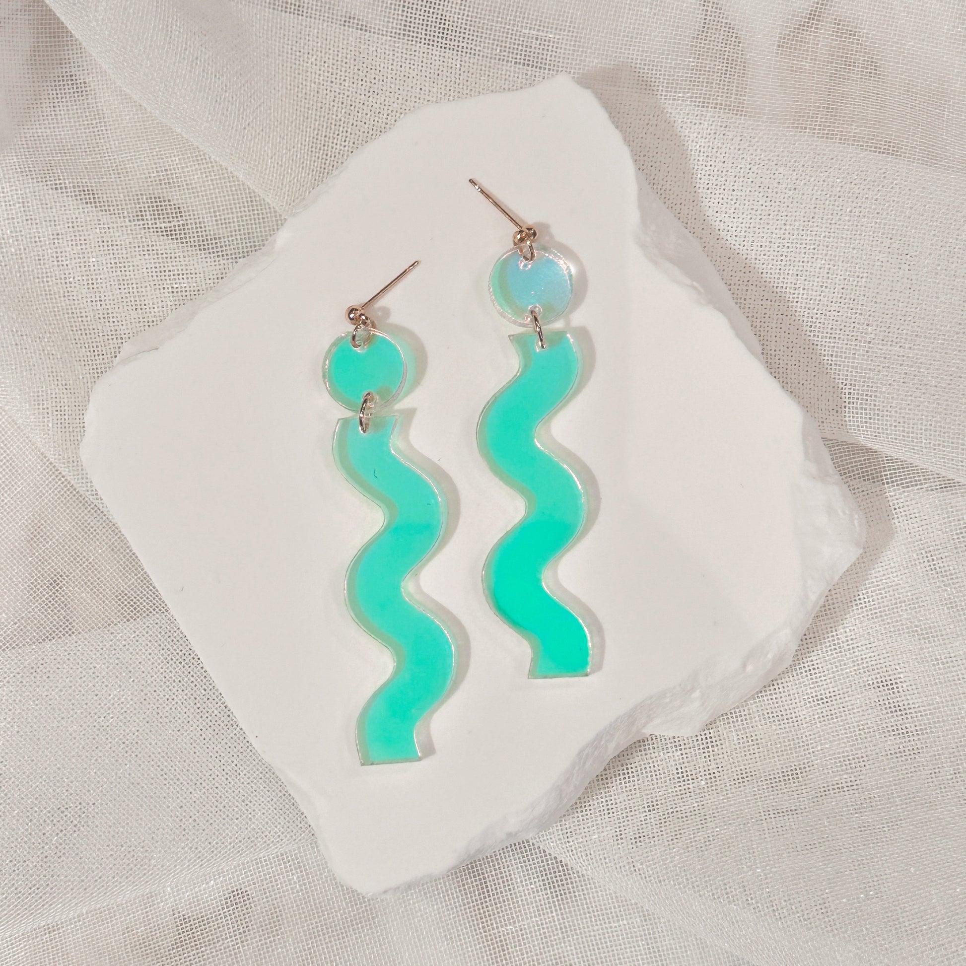 iridescent wave handmade earrings on display